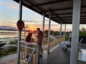 a man and a woman standing on a balcony with the sunset at ชมวิว บึงโขหลง in Ban Don Klang
