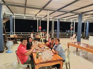 een groep mensen die aan een tafel zitten en eten bij ชมวิว บึงโขหลง in Ban Don Klang