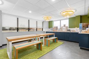 a cafeteria with tables and benches and a counter at Spark By Hilton Muskogee in Muskogee