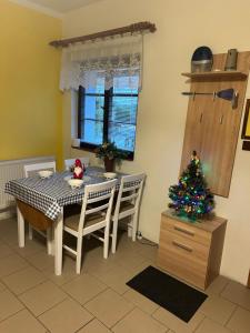 a dining room with a table and a christmas tree at Chaloupka in Karlova Studánka