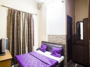 a purple bed in a room with a window at Hotel Grand in Dehradun