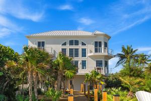una grande casa bianca con palme di fronte di 7791 Highway A1A a Ballard Pines