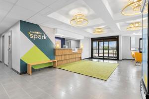an office with a waiting area with a bench and a desk at Spark By Hilton Muskogee in Muskogee