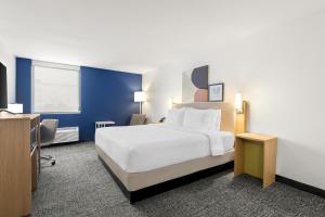 a hotel room with a large bed and a desk at Spark By Hilton Muskogee in Muskogee +9 photos