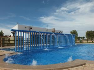 a pool with a blue fence and water at Casa del Fraile in Villarrobledo