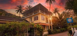 une maison dans une rue bordée de palmiers dans l'établissement GS Home on the Bay - Sea view room, à Vagator