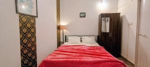 une chambre avec un lit avec une couverture rouge dans l'établissement GS Home on the Bay - Sea view room, à Vagator