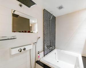 a white bathroom with a sink and a mirror at The Lime Hotel in Incheon