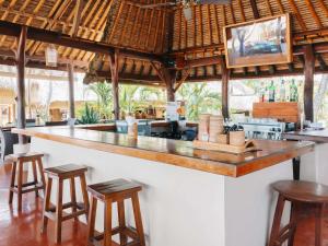 a bar in a restaurant with stools in front of it at Novotel Lombok Resort & Villas in Kuta Lombok
