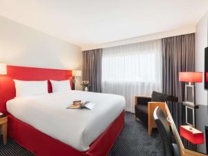 een hotelkamer met een groot bed met een rood hoofdeinde bij Mercure Paris CDG Airport & Convention in Roissy-en-France +105 foto's