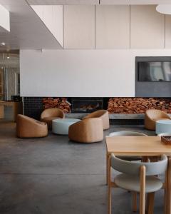 a room with a table and chairs and a fireplace at The Lodge Wadjemup in Rottnest Island
