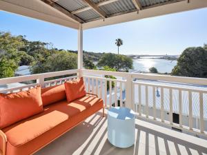 a balcony with a couch and a view of the water at The Lodge Wadjemup in Rottnest Island