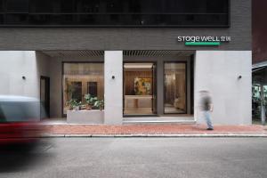a man walking in front of a store at Stage Well Hotel in Hong Kong