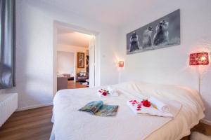 een slaapkamer met een wit bed met twee handdoeken erop bij Résidence Androsace 42 Happy Rentals in Chamonix-Mont-Blanc