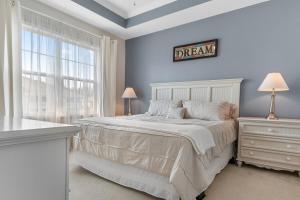 een slaapkamer met een bed en een bord aan de muur bij Stylish Barefoot Golf Condo with Pool Access in North Myrtle Beach
