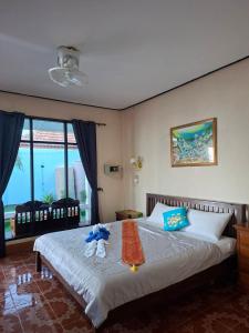 ein Schlafzimmer mit einem Bett mit zwei Stofftieren darauf in der Unterkunft Horizon Bungalow Koh-Lanta in Ko Lanta