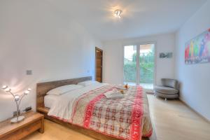 een slaapkamer met een groot bed en een stoel bij Rebecca Garden - Happy Rentals in Lugano