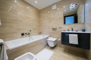 een badkamer met een bad, een toilet en een wastafel bij Rebecca Garden - Happy Rentals in Lugano