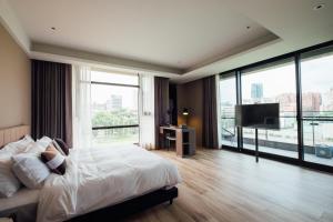 a bedroom with a large bed and a television at Chez Nous in Taipei