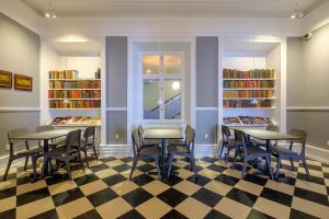 biblioteca con mesas, sillas y estanterías en Zleep Hotel Prindsen Roskilde, en Roskilde