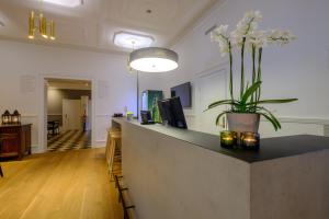 a reception counter with a vase of flowers on it at Zleep Hotel Prindsen Roskilde in Roskilde