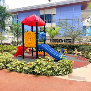 un parco giochi con scivolo di fronte a un edificio di The Executive Suite Cebu a Cebu City