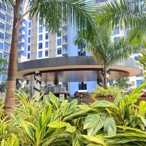 un edificio con palme e piante di fronte ad esso di The Executive Suite Cebu a Cebu City