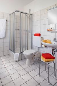 a bathroom with a shower and a toilet and a sink at Hotel-Pension Pöhling in Lippstadt