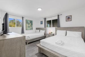 een slaapkamer met twee bedden en een flatscreen-tv bij Oceanview Azul 2BR • Bright Top-Floor Condo in Myrtle Beach