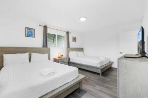 een slaapkamer met twee bedden en een televisie bij Oceanview Azul 2BR • Bright Top-Floor Condo in Myrtle Beach