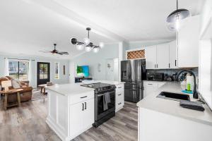 a kitchen with white cabinets and a stove top oven at Relax: Private Pool Grill Fire Pit in Myrtle Beach