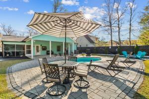 a patio with a table and chairs and an umbrella at Relax: Private Pool Grill Fire Pit in Myrtle Beach