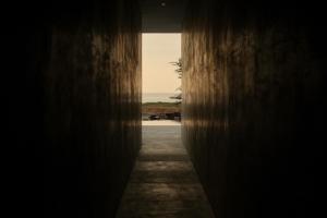 a hallway with a view of the ocean through a wall at Notto Zicatela Hotel in Puerto Escondido