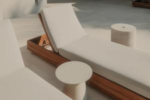 a white bed with a table and a stool at Notto Zicatela Hotel in Puerto Escondido