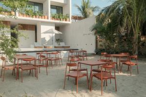 a group of tables and chairs in front of a building at Notto Zicatela Hotel in Puerto Escondido +50 photos