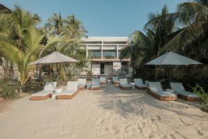 een groep stoelen en parasols op een strand bij Notto Zicatela Hotel in Brisas de Zicatela
