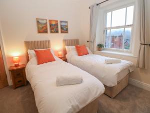 two twin beds in a room with a window at Dorset Villas in Matlock