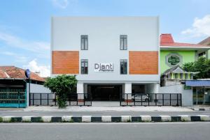 un edificio bianco con un cartello che dice bevanda di Vibes Djanti Residence Yogyakarta By Sans Hotel a Demangan