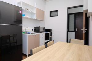 una cucina e una sala da pranzo con tavolo e frigorifero di Vibes Djanti Residence Yogyakarta By Sans Hotel a Demangan