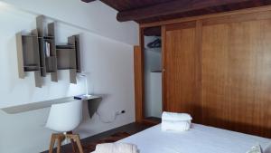 Schlafzimmer mit einem Bett und einer Holztür in der Unterkunft Appartamento Alloro 2 in Palermo
