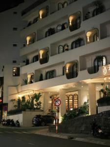 un grande edificio bianco con un'auto parcheggiata di fronte di Túi Ba Gang Central Hotel a Da Lat Altre 109 foto