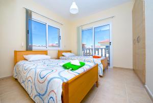 a bedroom with two beds and a balcony at Villa Agnes in Ayia Napa