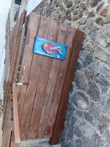 een houten deur met een schildering van een vis erop bij La Oursha Apartment in Pointe aux Biches