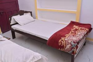 una camera con 2 letti a castello e coperta rossa e bianca di Luv Kush Homestay Ayodhya call now- 7,5,6,5,9,2,4,8,4,4 a Ayodhya Altre 2 foto