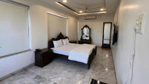 a bedroom with a large bed and a mirror at Urban Nest in Nagpur