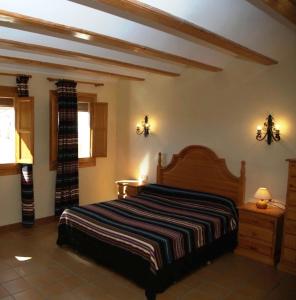 a bedroom with a bed and two lights on the wall at Casa Puritat in Morella