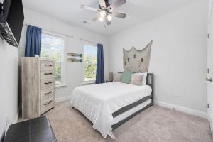 a white bedroom with a bed and a ceiling fan at Birdie Bungalow- Games Beach Gear Sleeps 10 in Myrtle Beach +48 photos