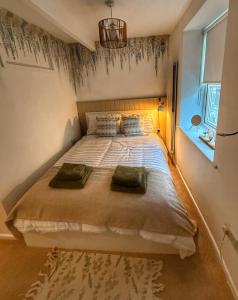 een slaapkamer met een groot bed met twee kussens bij Orchard Nook Cottage in Barnoldswick +2 foto's