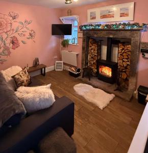 een woonkamer met open haard en een bank bij Orchard Nook Cottage in Barnoldswick