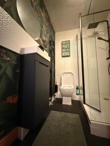 a bathroom with a toilet and a glass shower at Orchard Nook Cottage, 1 bedroom in Barnoldswick